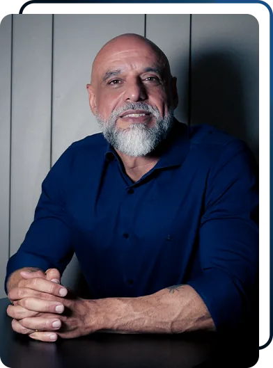 Dr. Celso Boaventura sentado à mesa, de camisa azul
